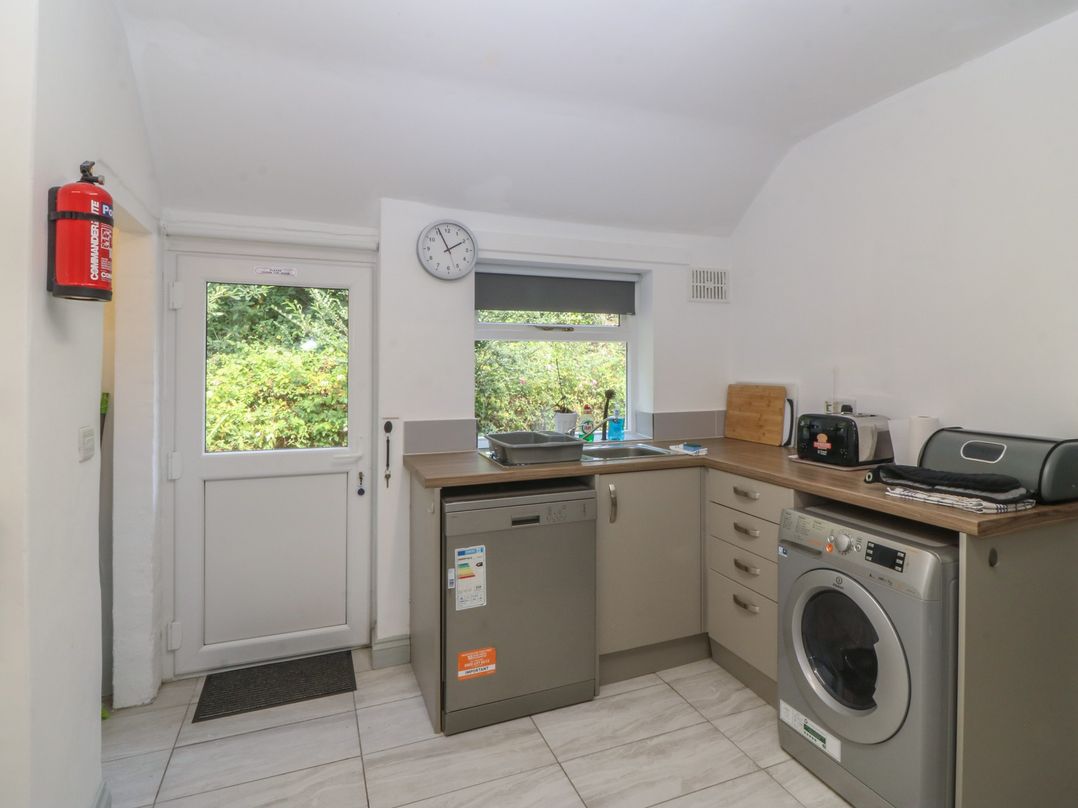 A kitchen with appliances and a door at Seaview Hafod Y Graig in Morfa Bychan