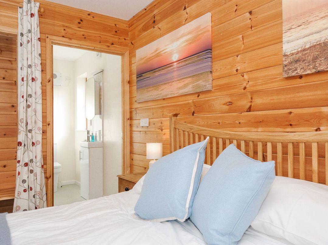 A bedroom with a bed and attached bathroom at Polzeath in St Breward