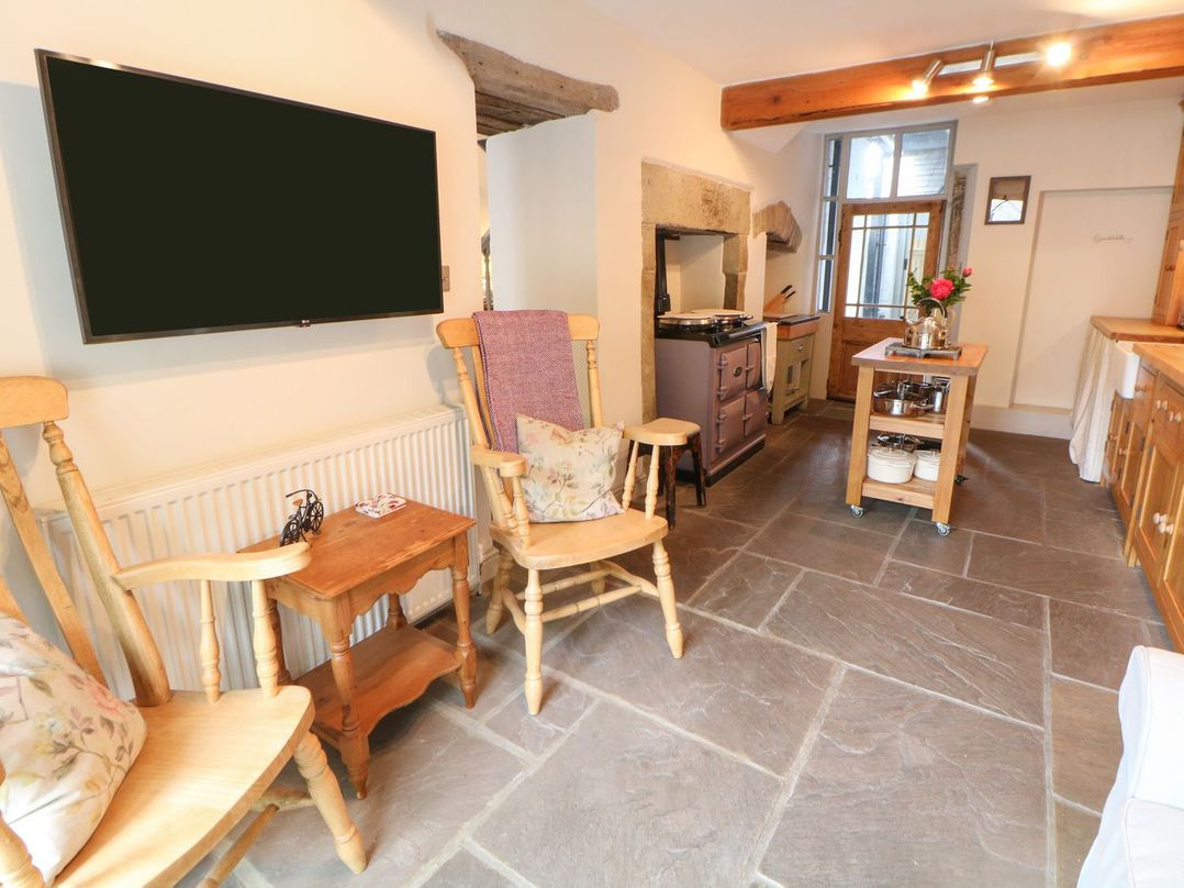 A kitchen with a television and wooden furniture at Billy Whiskey's in Tideswell