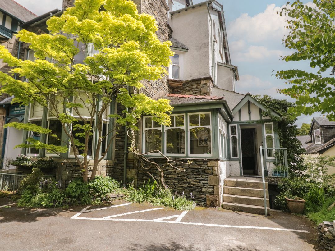 An exterior view of a house with a tree and parking space at The Boundary in Windermere