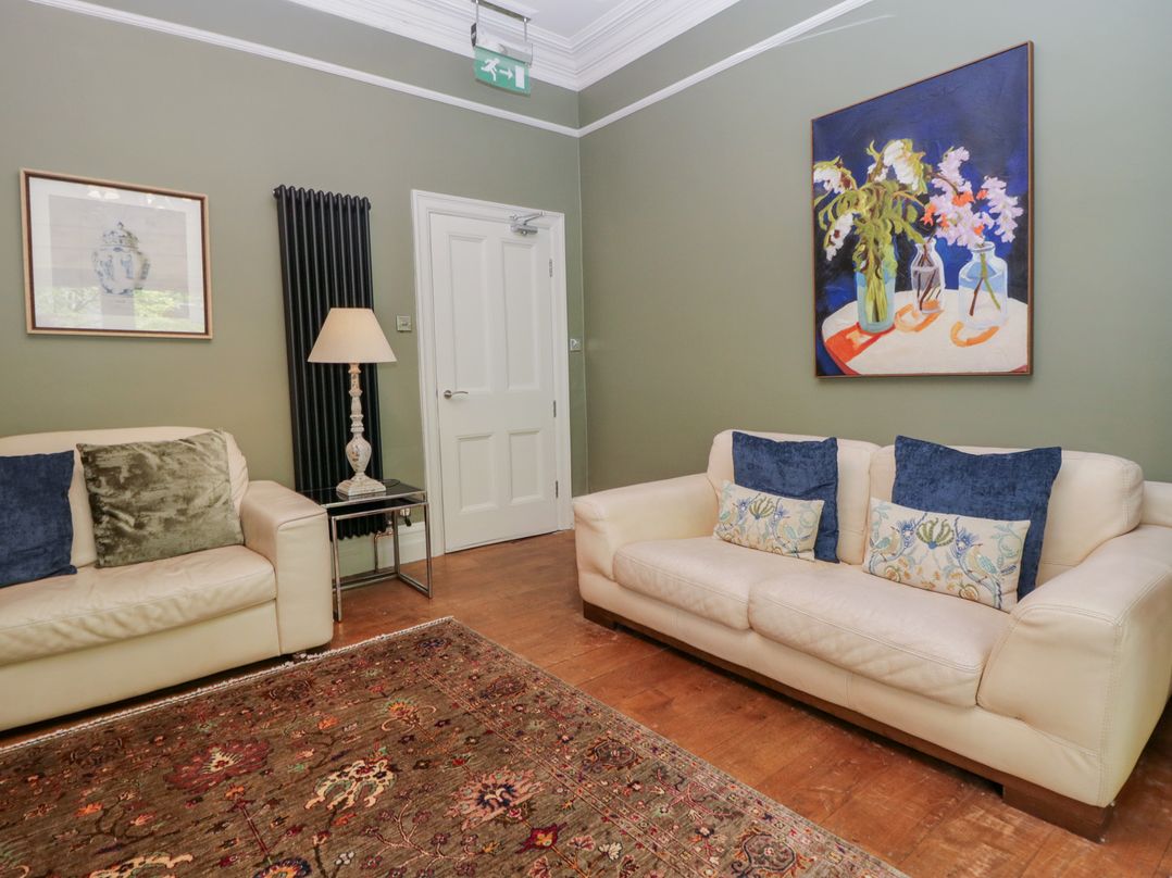 A living room with a sofa and a painting at The Boundary in Windermere