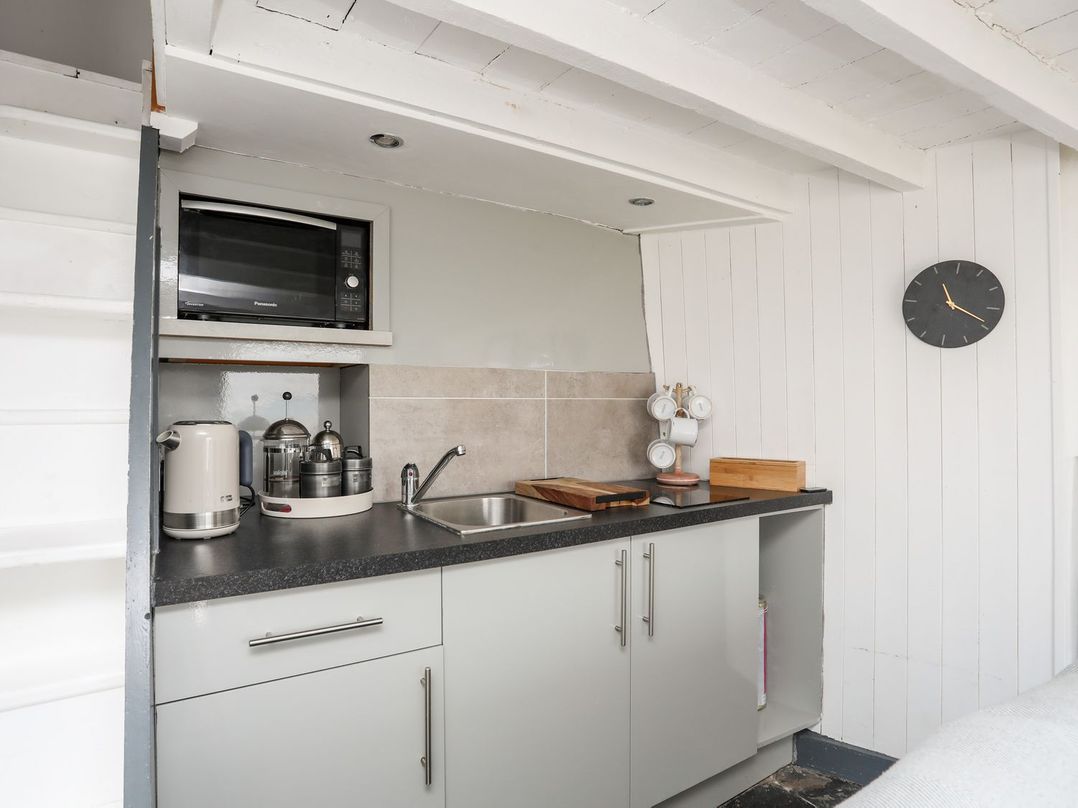 A kitchen with a sink and a microwave at The Ingle in Barmouth