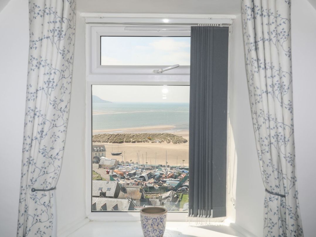 A view from a window showing the sea and boats at The Ingle in Barmouth
