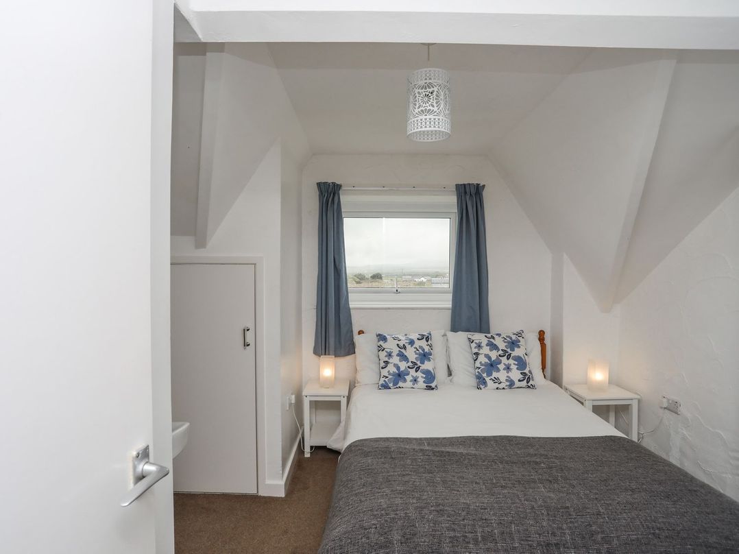 A bedroom with a bed and bedside tables at Cilan - 2 Ty'n Don Llanengan near Abersoch