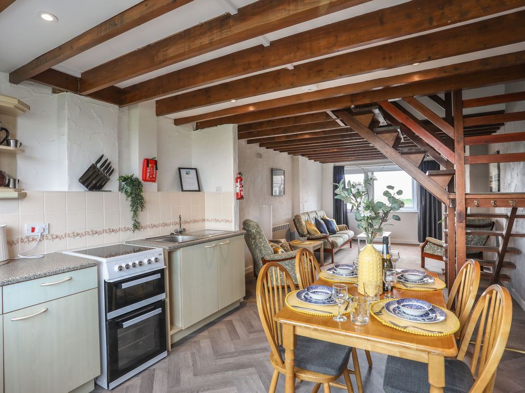 A kitchen with dining table and sofa at Fadrun - 3 Ty'n Don