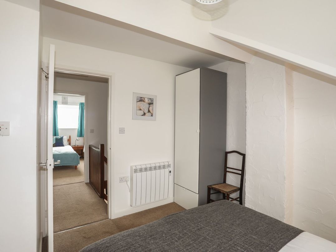 A bedroom with a bed and wardrobe at Fadrun - 3 Ty'n Don