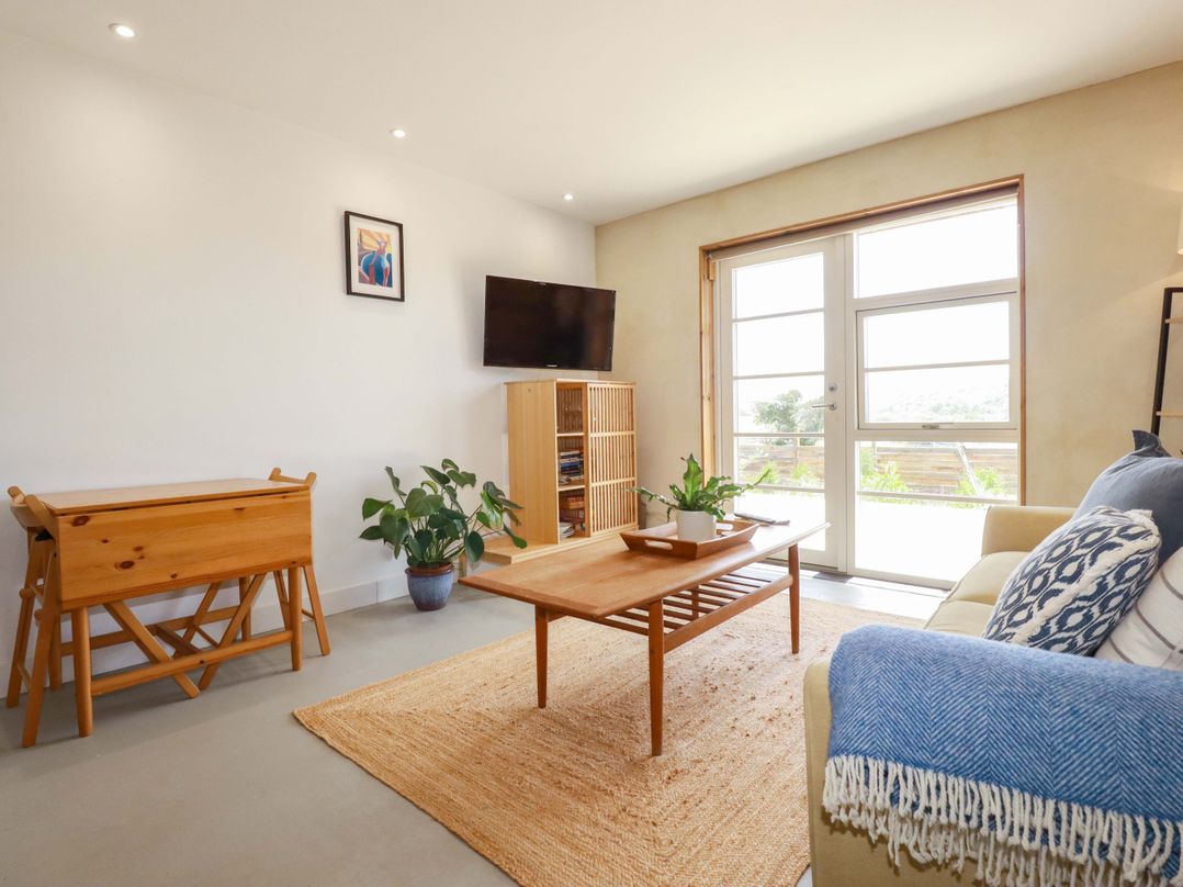 A living room with a sofa and coffee table at Teach Tra West in Perranporth