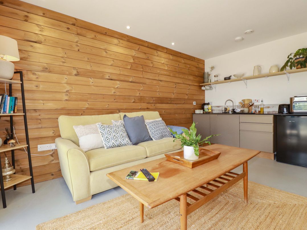 A living room with a sofa and coffee table at Teach Tra West in Perranporth