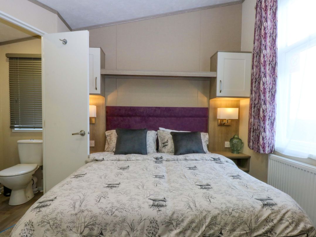 A bedroom with a bed and a toilet at Blue Skies Caernarfon