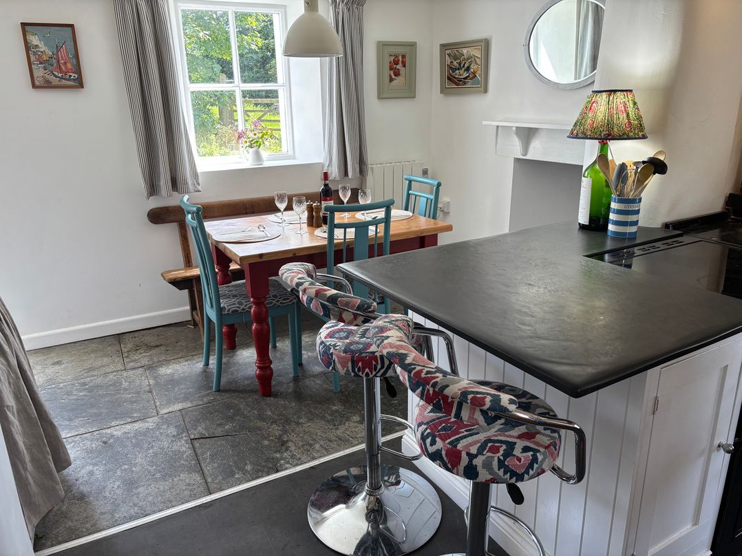A kitchen with a dining area and bar stools at Old Sunday School in Welcombe