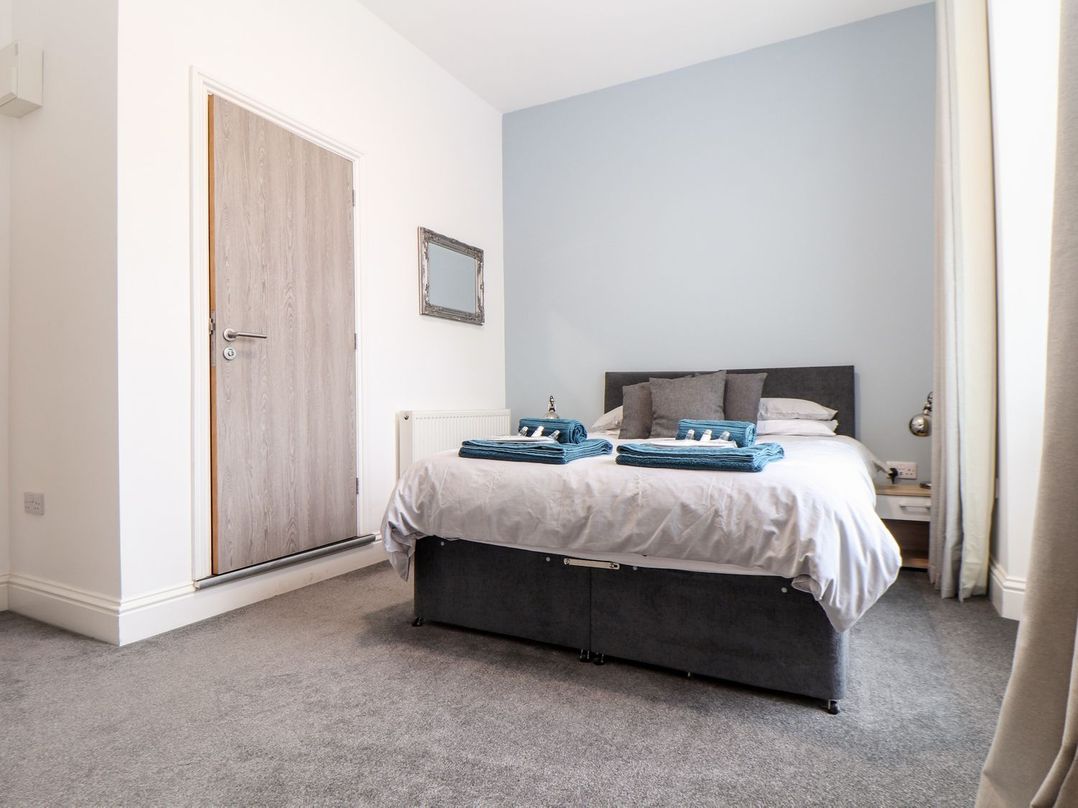 A bedroom with a bed and a door at Teylu in Camborne