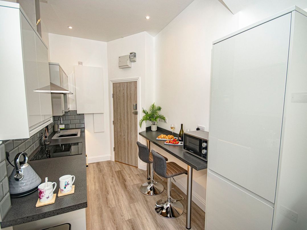 A kitchen with a countertop and bar stools at Daniel Chambers in Camborne