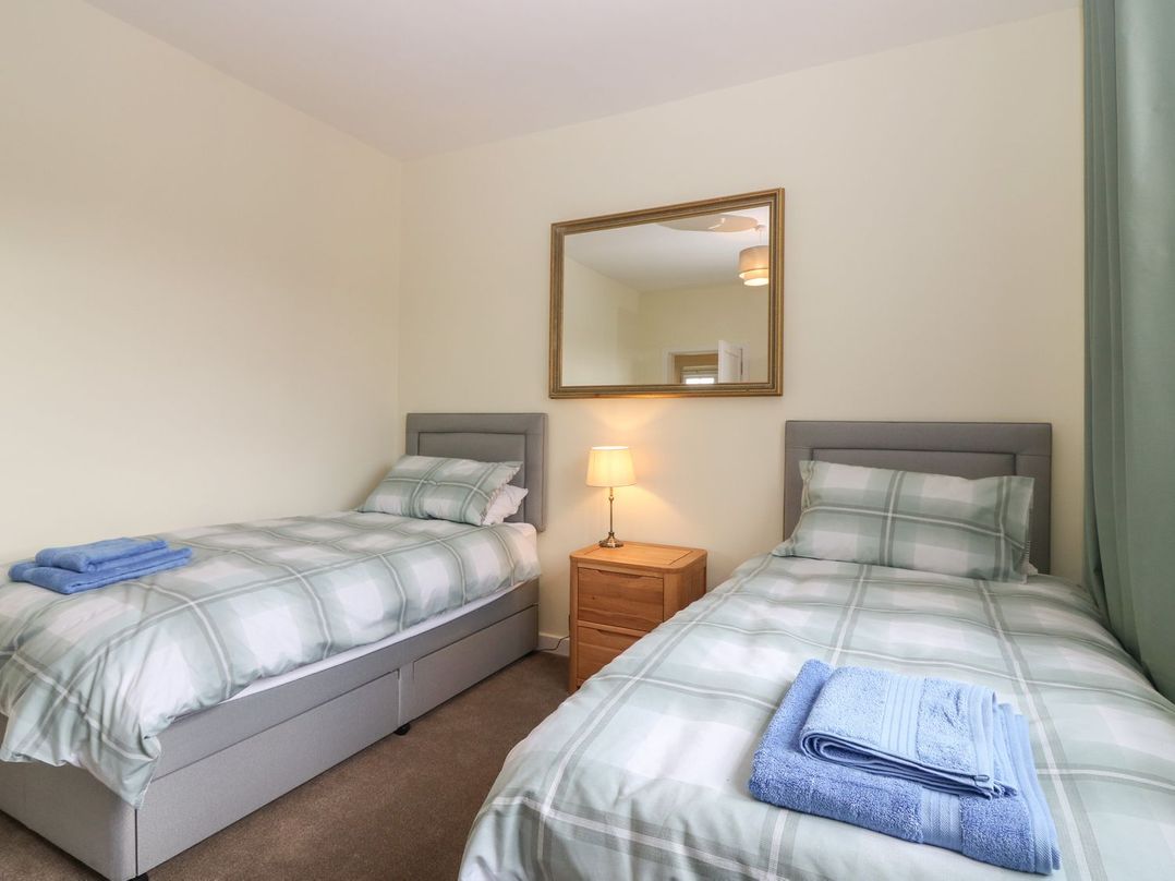 A bedroom with two beds and a lamp at Bankhead Of Lour Bungalow