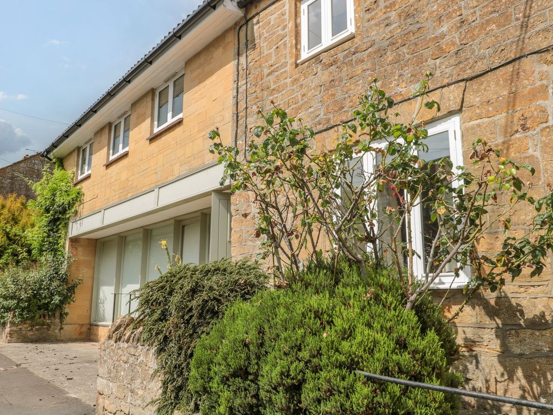 An outdoor view of a building with windows and greenery at Greenham Rise Norton-Sub-Hamdon