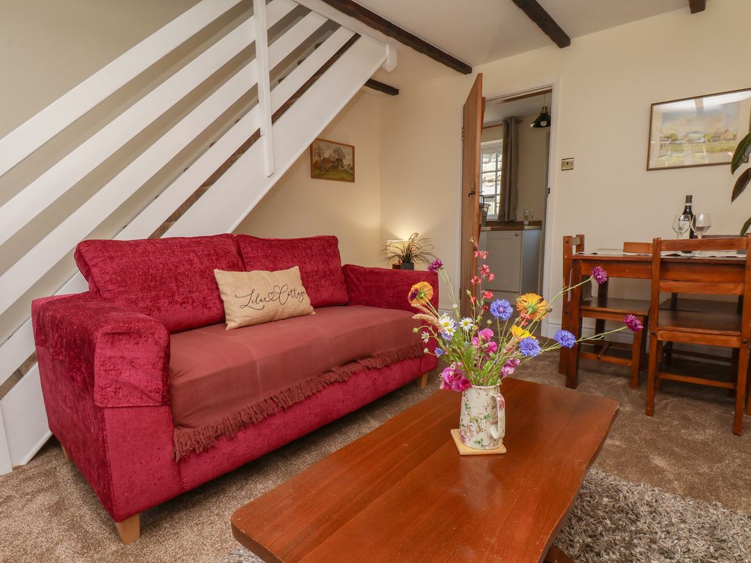 A living room with a sofa and dining area at 4 Lilac Cottages Ainthorpe