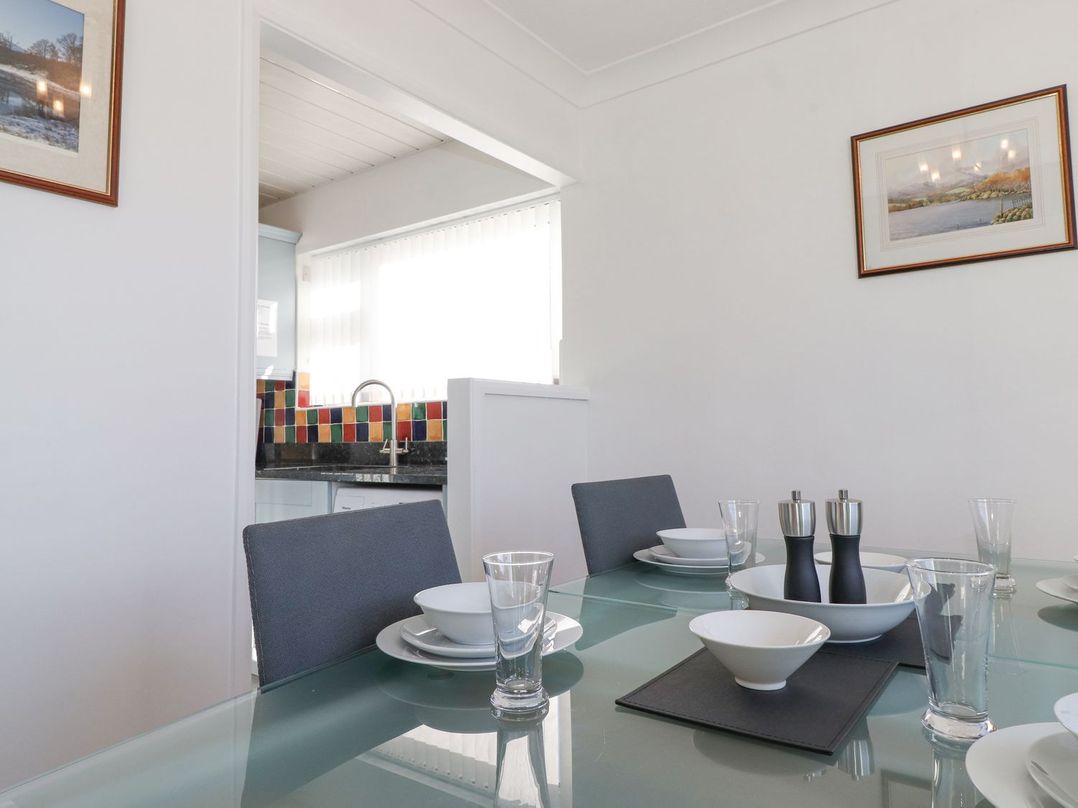 A dining room with a table set for meals at Wansfell View in Ambleside