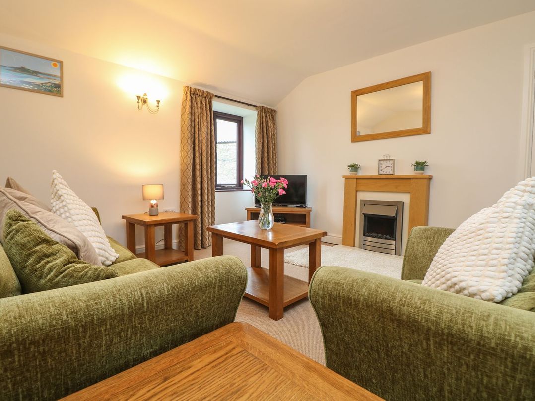 A living room with a sofa and coffee table at Little Tregarrick in Helston