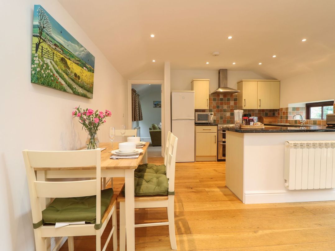 A kitchen with a table and chairs at Little Tregarrick in Helston