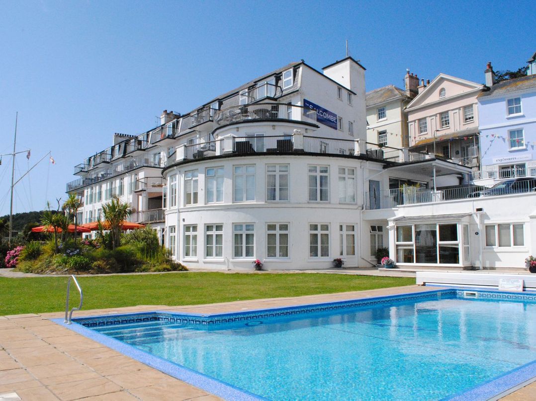 A building with a swimming pool and grass area at 3 The Salcombe in Salcombe