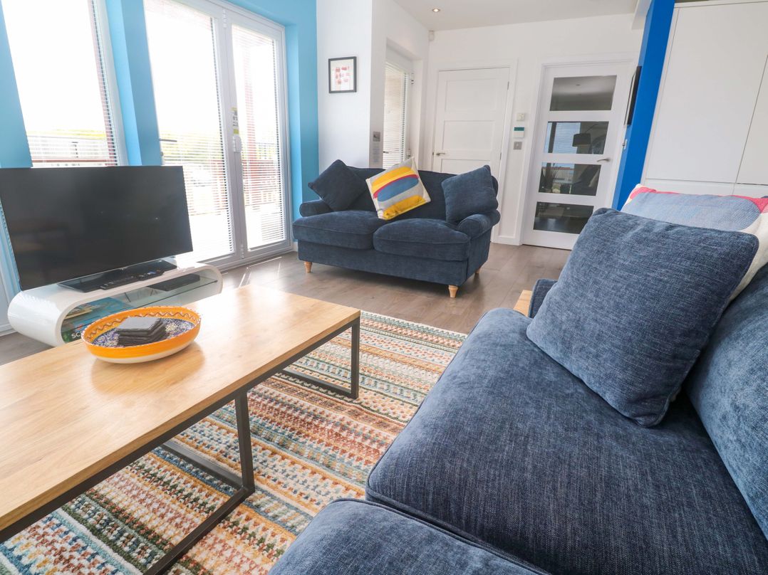 A living room with a television and a coffee table at Pentewan - 67 Portreath