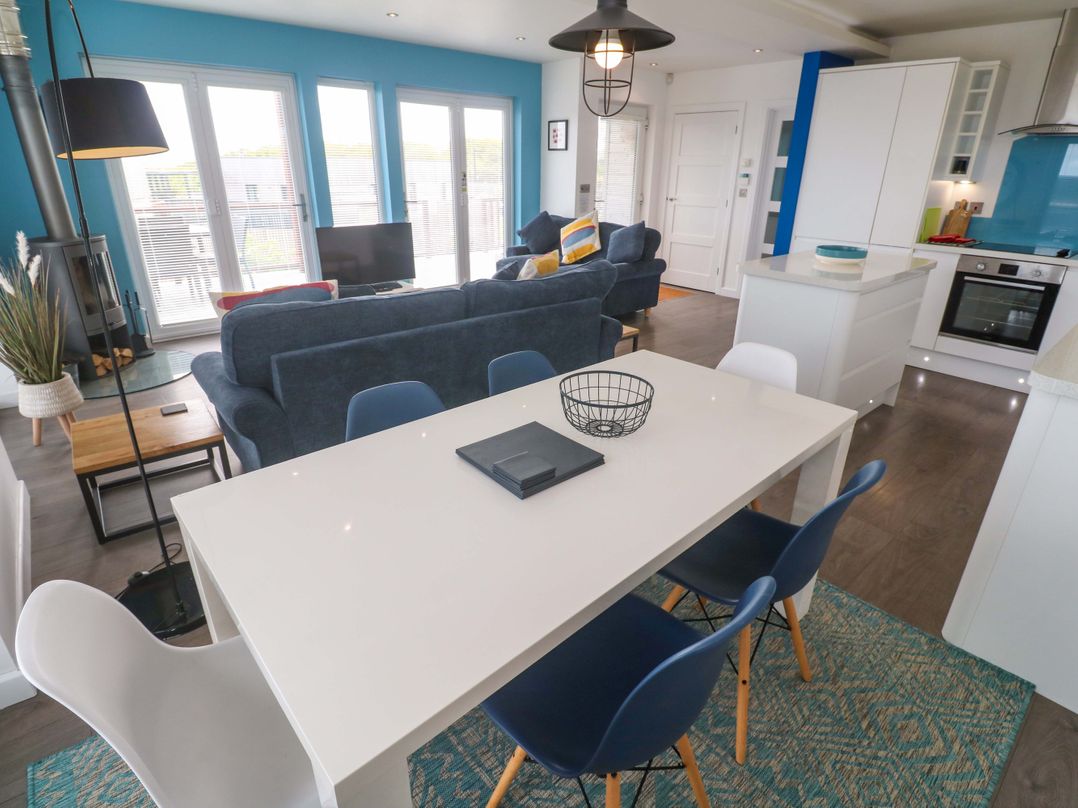 A living room with a sofa and dining area at Pentewan - 67 Portreath