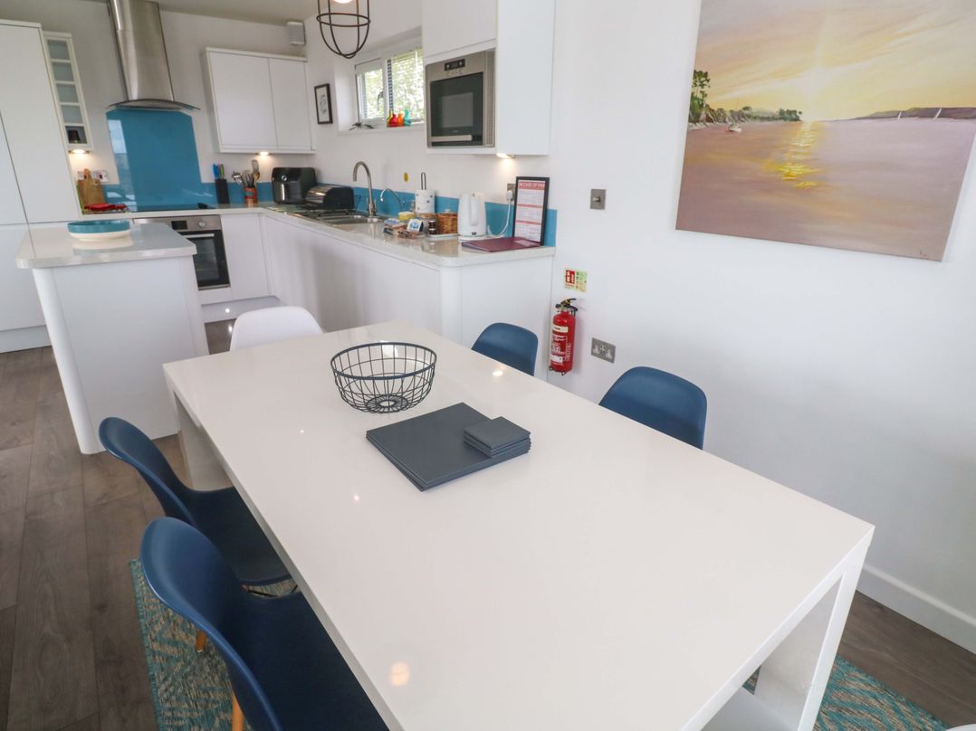 A kitchen with a dining table and chairs at Pentewan - 67 in Portreath