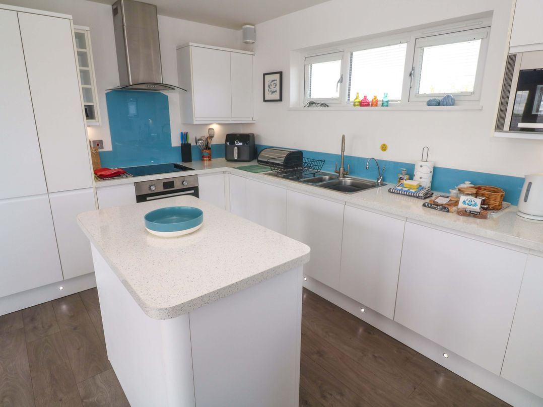 A kitchen with modern appliances and a spacious island at Pentewan - 67 in Portreath