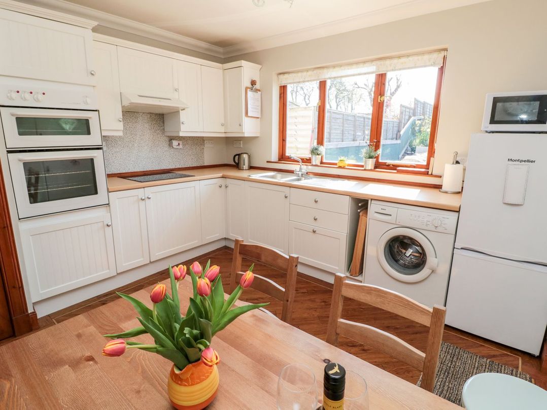 A kitchen with white cabinets and appliances at Cygnet Cottage Berwick-upon-Tweed
