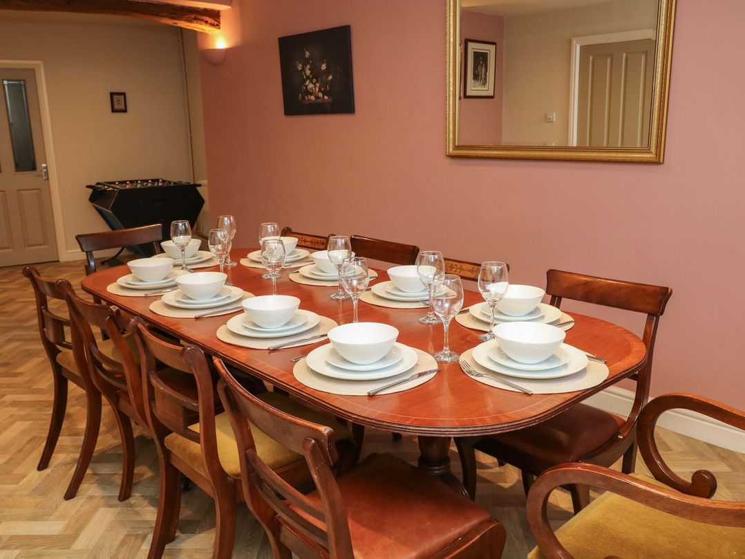 A dining room with a long table set for a meal at The Annexe in Belper