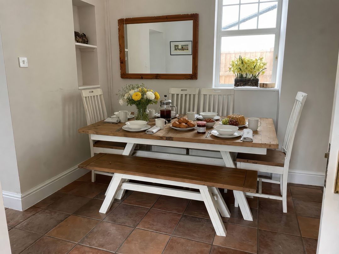 A dining room with a table and chairs at Bryniau in Morfa Nefyn