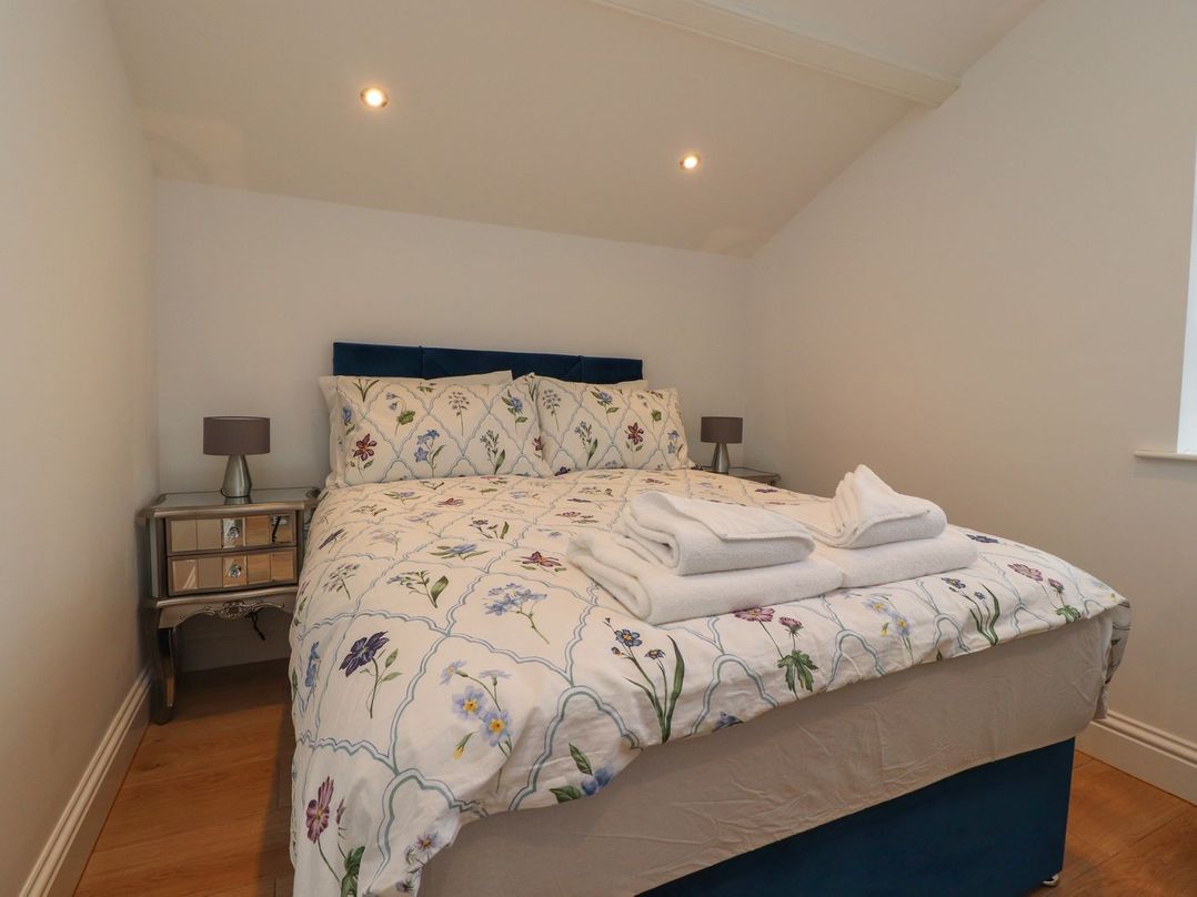 A bedroom with a bed and bedside table at The Lodge House in Dolphinholme near Galgate
