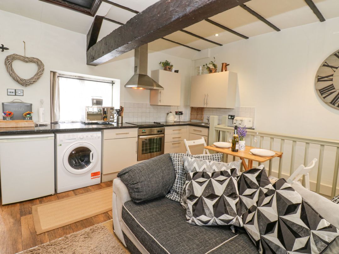 A kitchen with appliances and dining area at In & Out Cottage Leyburn