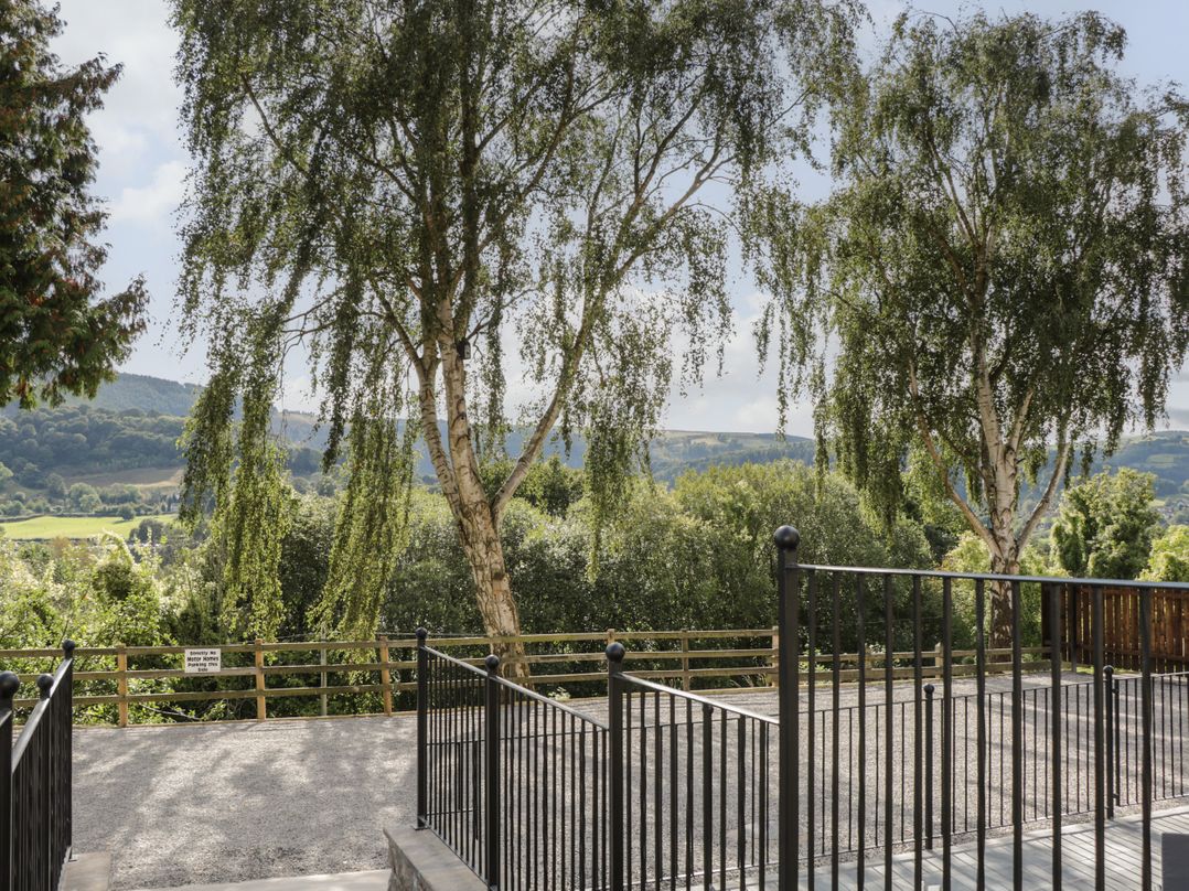 A view of trees and landscape from a terrace at Sun Trevor Barn 1 in Llangollen