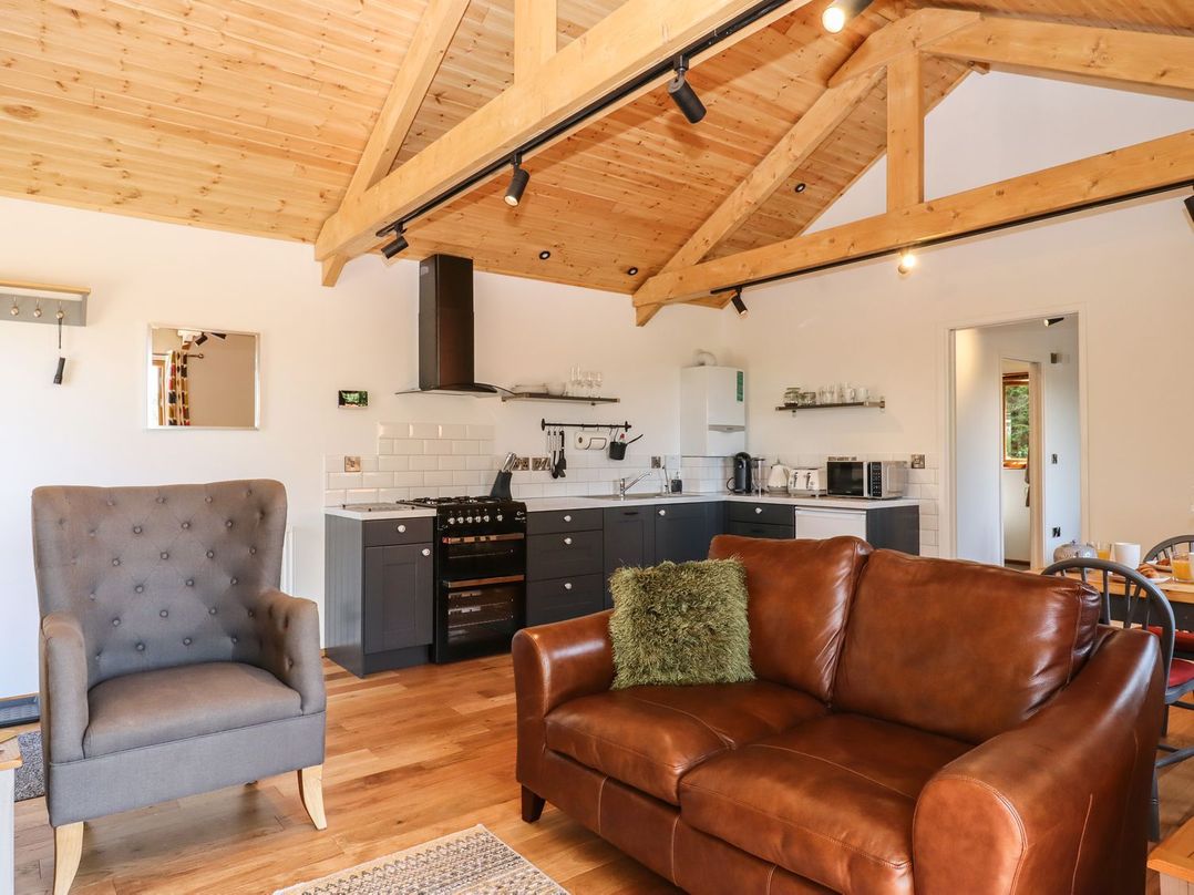 A living room with a sofa and an armchair at Nelli Lodge at Mile End Crediton