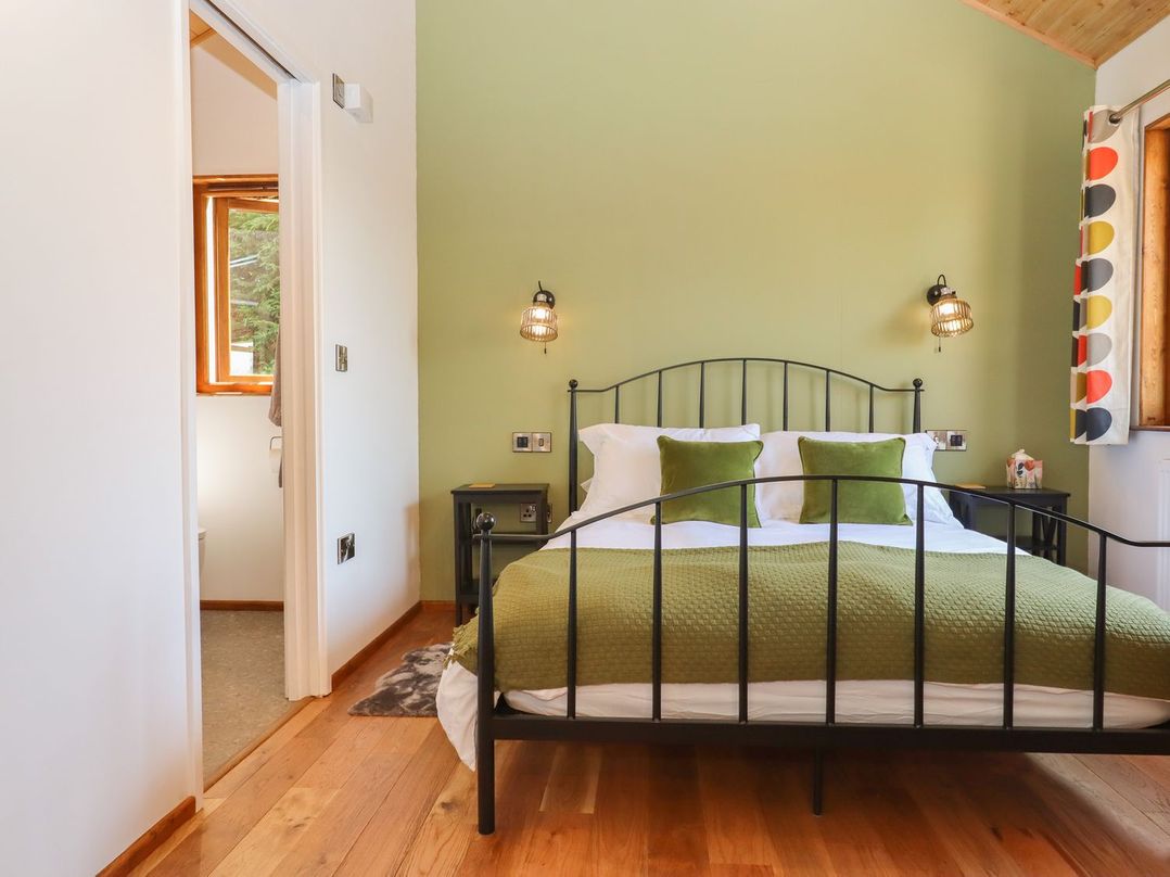 A bedroom with a bed and window at Nelli Lodge at Mile End, Crediton