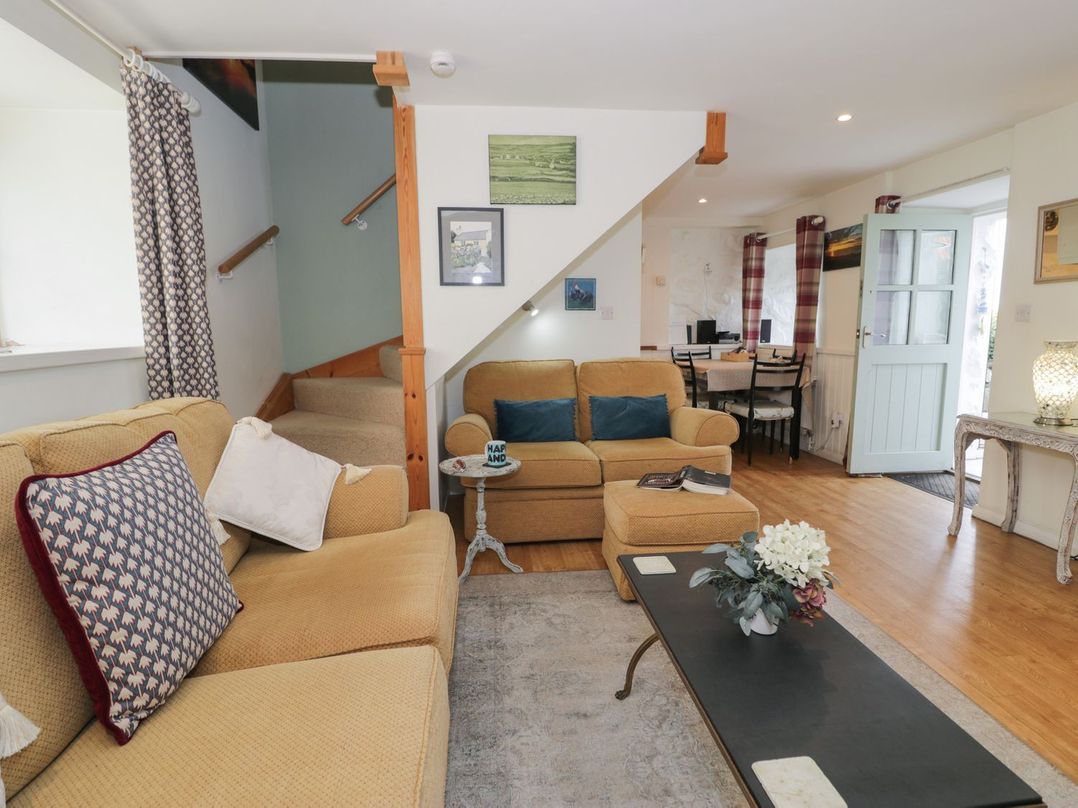 A living room with a sofa and coffee table at Happy Landing in Harlech