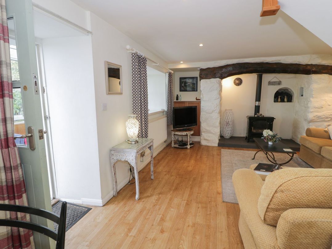 A living room with a television and a fireplace at Happy Landing in Harlech