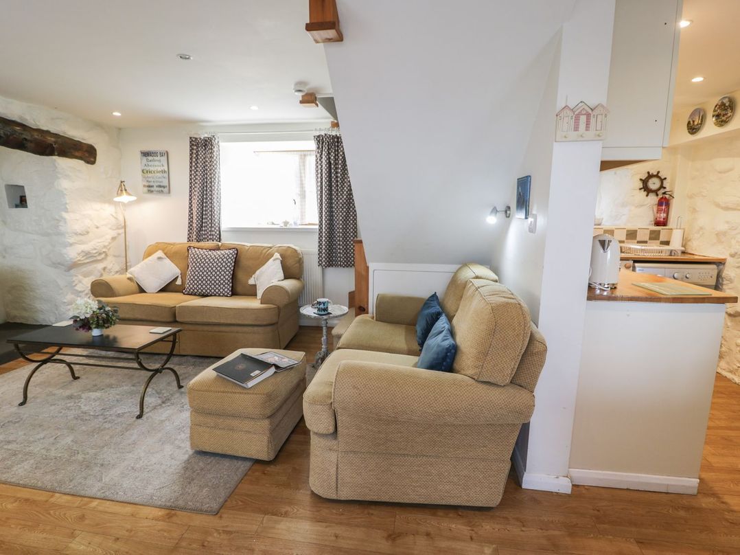 A living room with a sofa and coffee table at Happy Landing in Harlech