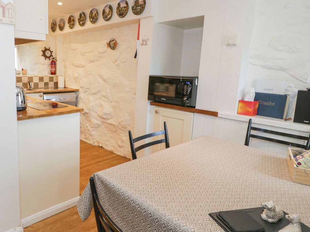 A kitchen with a table and chairs at Happy Landing in Harlech