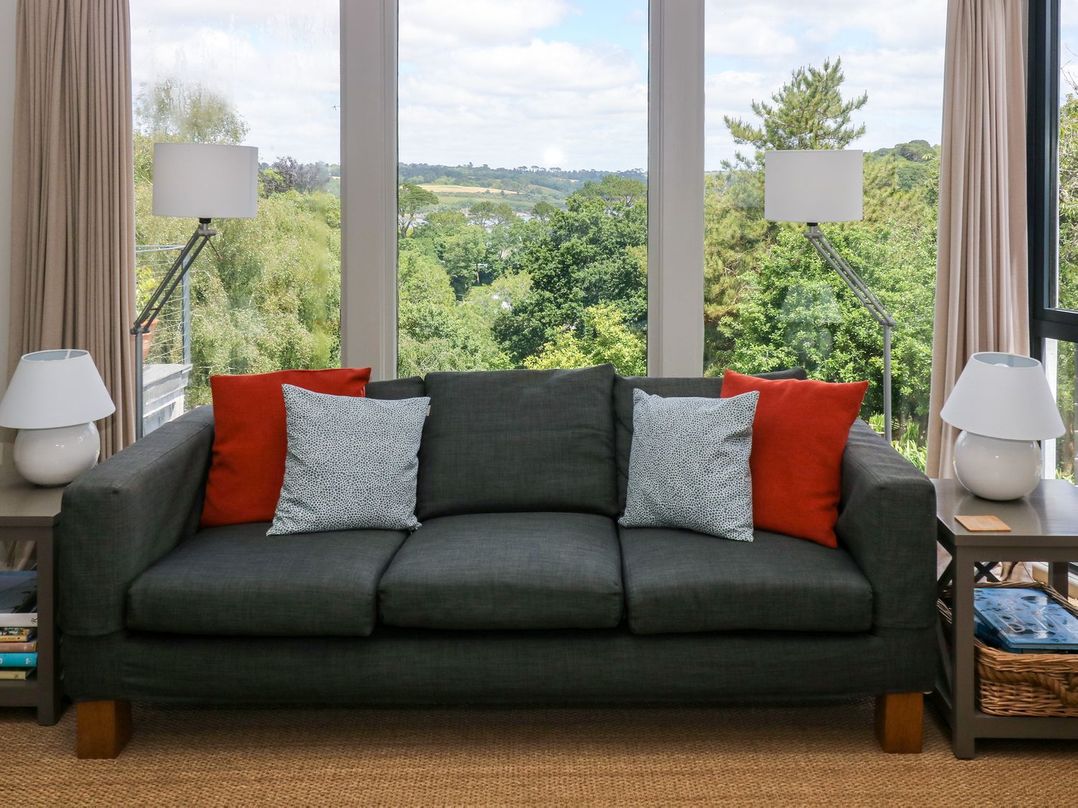 A living room with a sofa and lamps at Wood Meadow in Helston