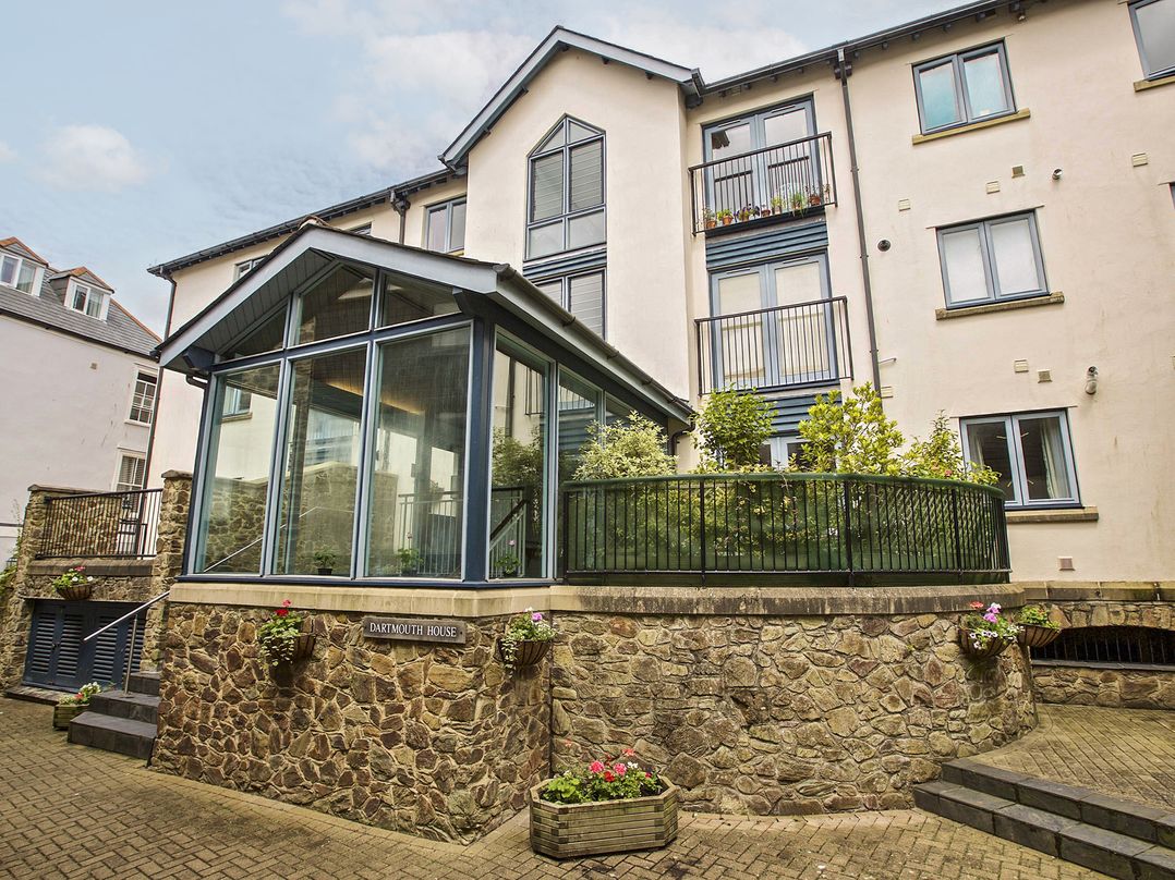 A glass extension with a garden area and stone wall at 6 Dartmouth House, Dartmouth