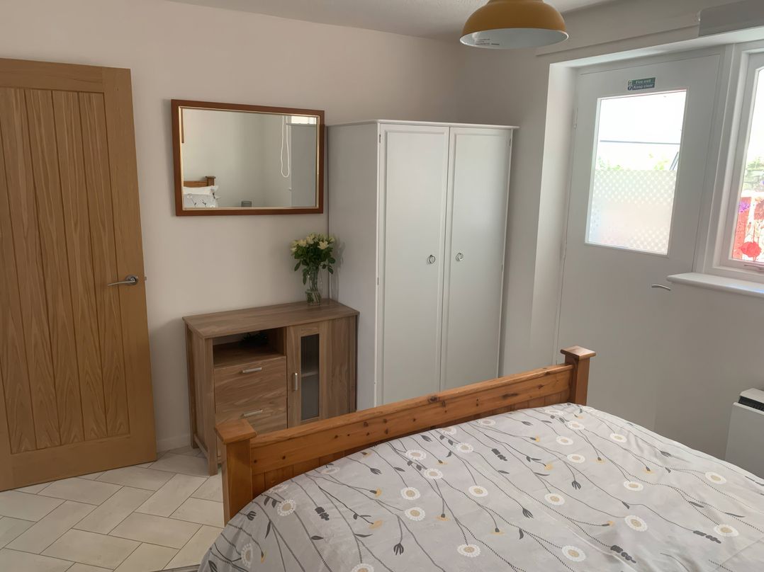 A bedroom with a bed and mirror at Amber House Dorchester