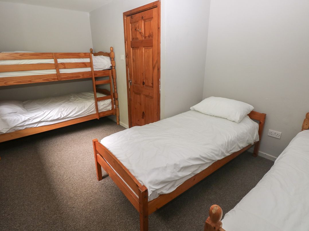 A bedroom with bunk beds and two single beds at Cabin No. 9 - Salt and Fern Cabins in Goytre near Port Talbot