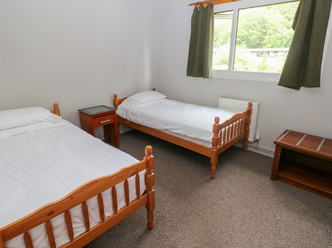 A bedroom with two beds and a nightstand at Cabin No. 10 - Salt and Fern Cabins Goytre near Port Talbot