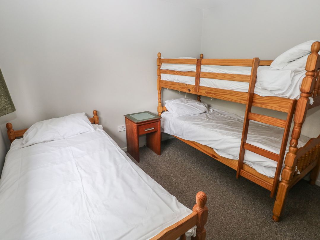 A bedroom with a bunk bed and a single bed at Cabin No. 10 - Salt and Fern Cabins, Goytre near Port Talbot