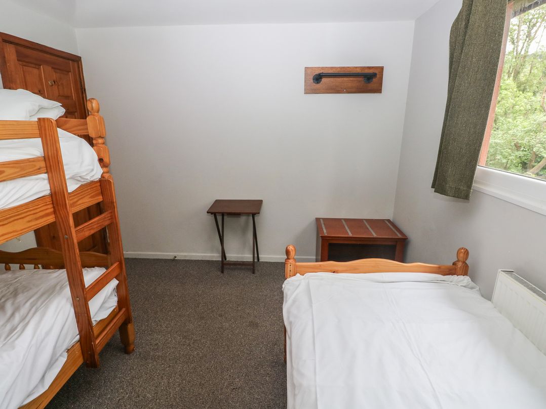 A bedroom with a bunk bed and a single bed at Cabin No. 10 - Salt and Fern Cabins Goytre near Port Talbot