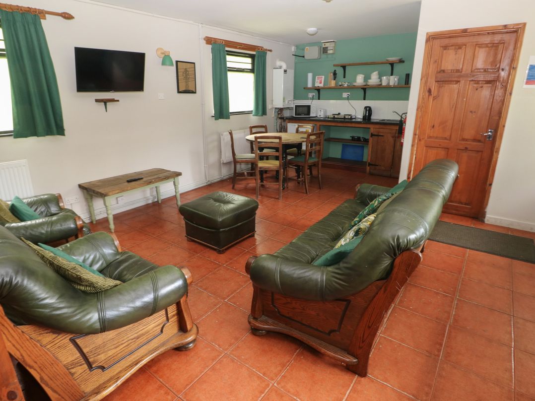 A living room with sofas and dining area at Cabin No. 12 - Salt and Fern Cabins Goytre near Port Talbot