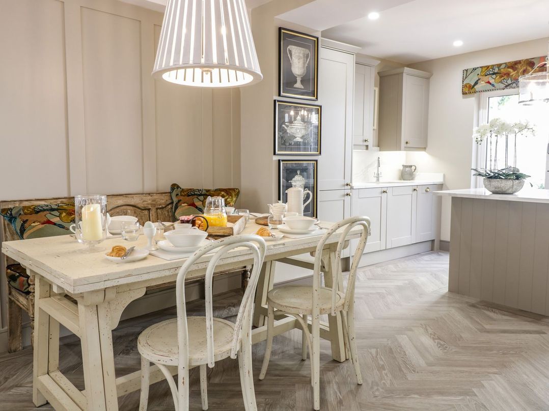 A kitchen with a dining area featuring a table and chairs at 2 Llewelyn Street Conwy