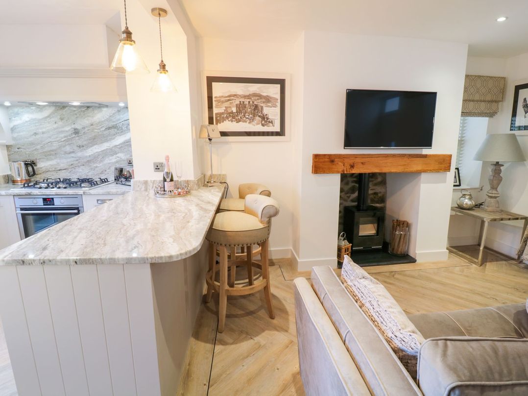 A living room with a television and fireplace at 8 Crown Lane in Conwy