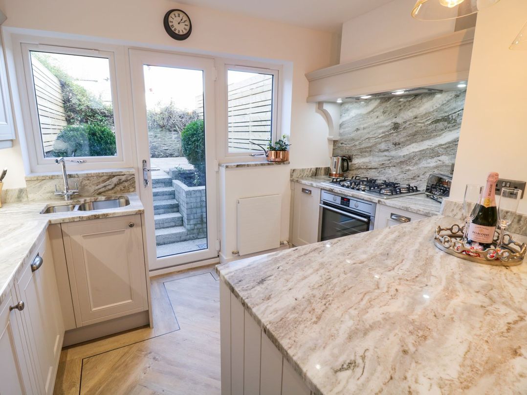 A kitchen with a window and steps leading outside at 8 Crown Lane Conwy